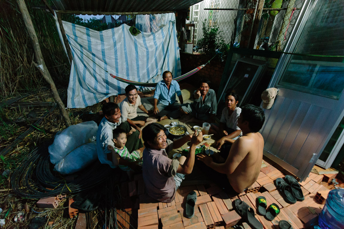 Local Vietnamese family enjoying food and rice wine at dinner